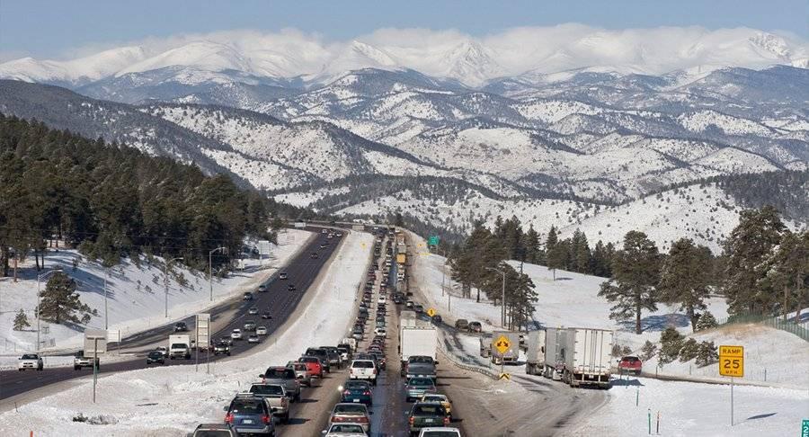 Holiday traffic jam on a snowy highway by the mountains.